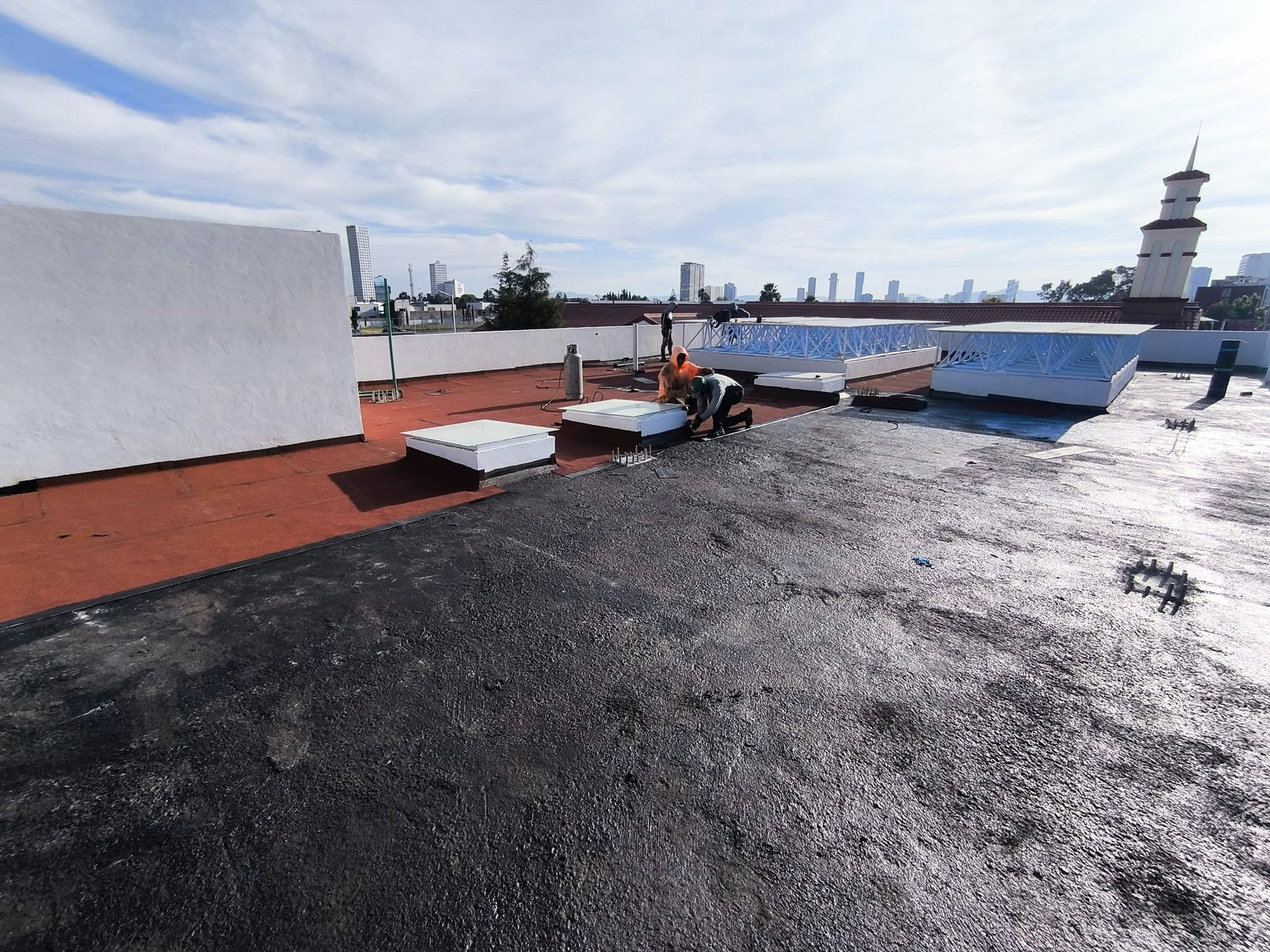 Trabajador aplicando impermeabilizante prefabricado